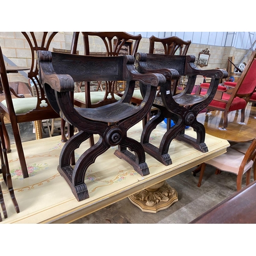 1153 - A pair of 19th century Spanish embossed leather and carved walnut framed 'X'  framed armchairs, widt... 