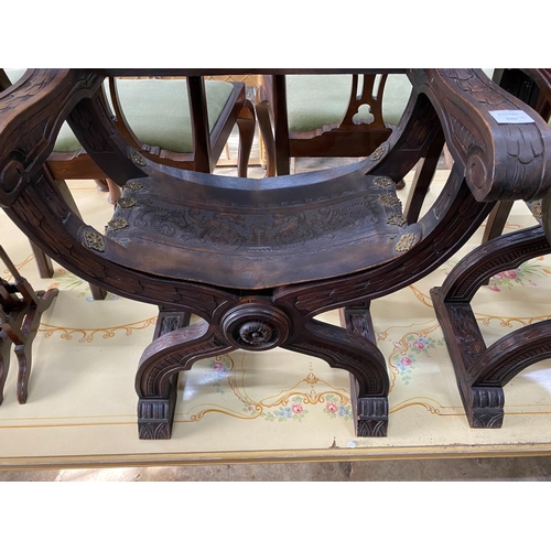 1153 - A pair of 19th century Spanish embossed leather and carved walnut framed 'X'  framed armchairs, widt... 