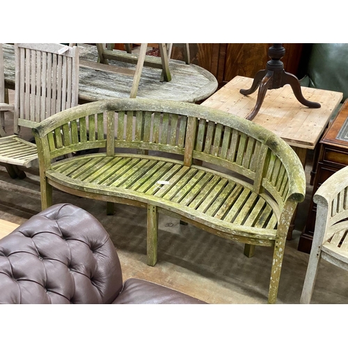 1161 - A pair of weathered teak 'banana' garden benches, length 158cm, depth 60cm, height 84cm (one with mi... 