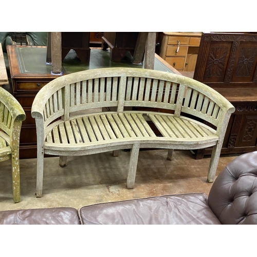 1161 - A pair of weathered teak 'banana' garden benches, length 158cm, depth 60cm, height 84cm (one with mi... 