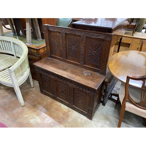 1163 - A carved and panelled oak settle incorporating old timber, width 106cm, depth 34cm, height 114cm... 