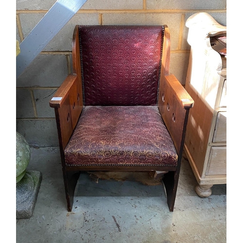 1193 - An early 20th century Arts & Crafts oak armchair, with pierced sides and embossed leather seat and b... 