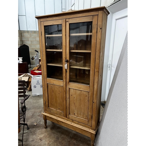 1221 - A Victorian glazed pine two door cabinet on stand, width 96cm, depth 27cm, height 182cm