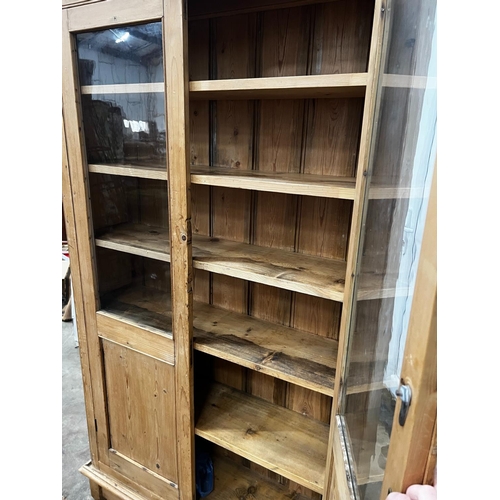 1221 - A Victorian glazed pine two door cabinet on stand, width 96cm, depth 27cm, height 182cm