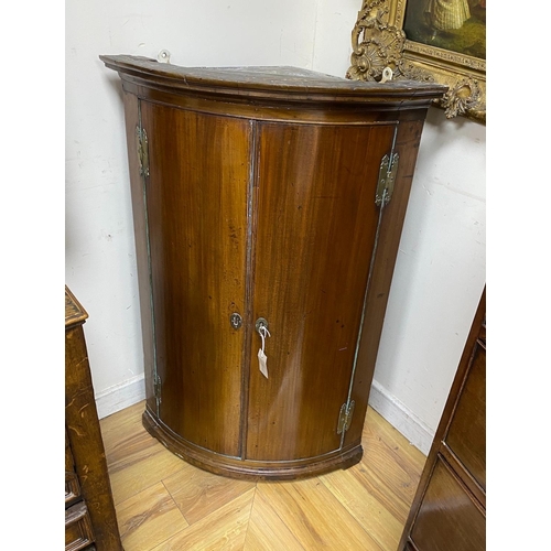 1228A - A George III mahogany bow front hanging corner cupboard, width 69cm, depth 49cm, height 105cm