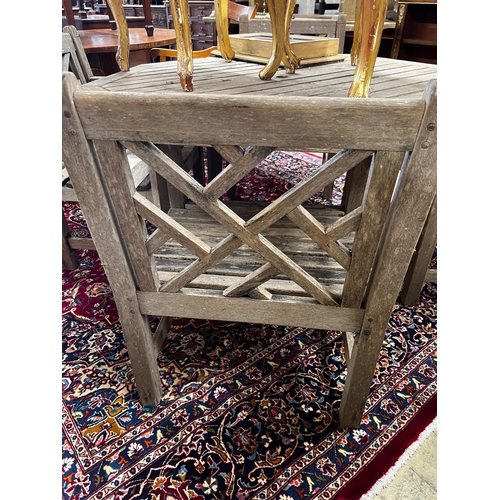 111 - An octagonal weathered teak garden table, length 126cm, height 69cm and four teak elbow chairs... 