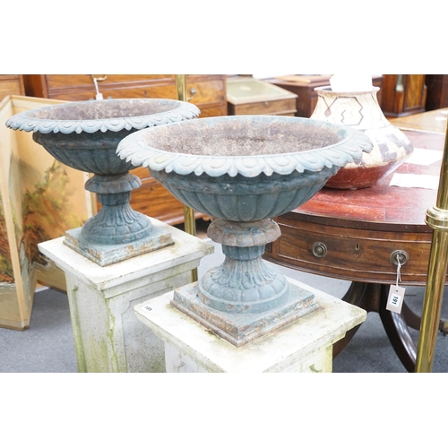 189 - A pair of Victorian painted cast iron campana garden urns on square stone plinths, diameter 51cm, he... 