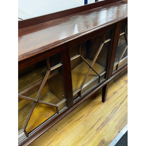 200 - An Edwardian glazed mahogany dwarf bookcase, enclosed by six astragal glazed sliding doors, width 29... 