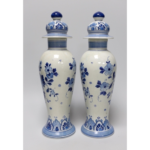 253 - A pair of blue and white Delft vases and covers, 28cm