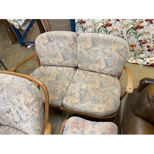 1111 - An Ercol elm three piece suite comprising settee, armchair and footstool