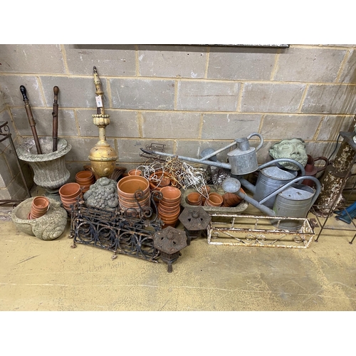 1165 - A large quantity of assorted garden ornaments, terracotta pots, galvanised watering cans, bench ends... 