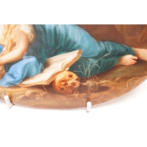 1258 - A 19th century painted porcelain oval plaque of a reclining lady reading a book. The reverse stamped... 