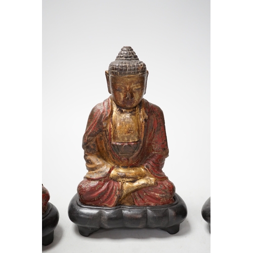 1264 - A set of three Chinese polychrome lacquered wood seated figures of Buddha, 19cm