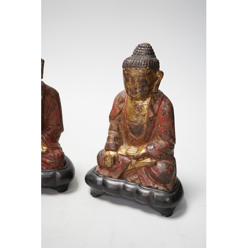 1264 - A set of three Chinese polychrome lacquered wood seated figures of Buddha, 19cm