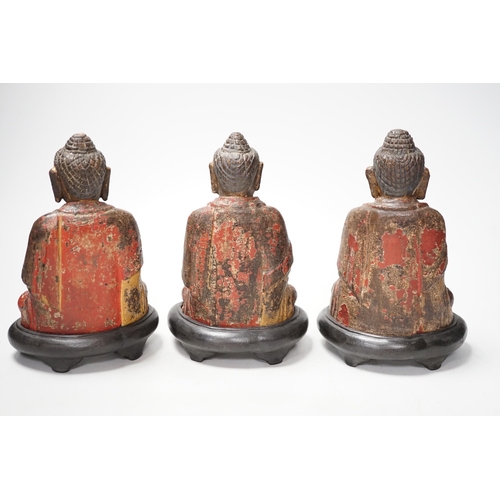 1264 - A set of three Chinese polychrome lacquered wood seated figures of Buddha, 19cm