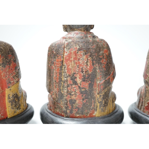 1264 - A set of three Chinese polychrome lacquered wood seated figures of Buddha, 19cm