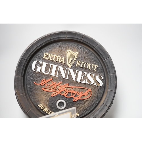 1283 - A Guinness time illuminating timepiece, Guinness display light and a Guinness advertising barrel cov... 