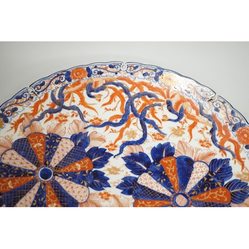 1396 - An Imari petal rimmed charger, in typical palette, Meiji period. 47cm