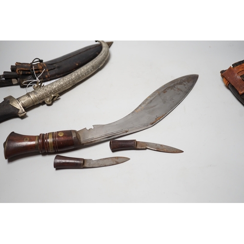 1523 - Two Kukri and eastern daggers, within engraved sheath, (3)