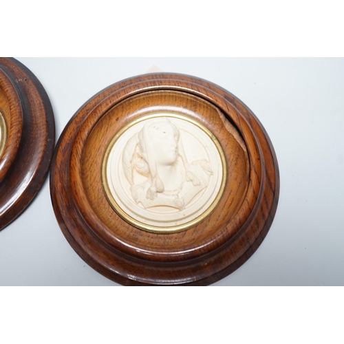 1536 - A pair of late 19th century carved and moulded composition portrait roundels, in oak frames