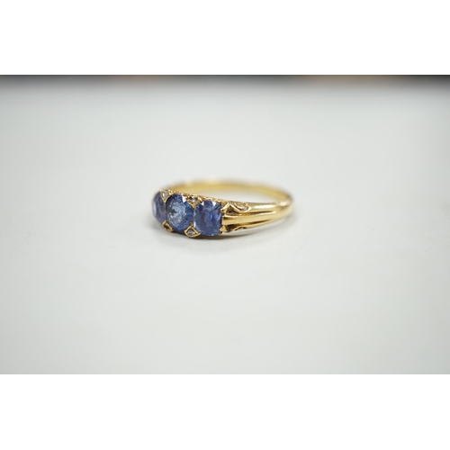 1924 - An early 20th century 18ct and three stone sapphire set half hoop ring, with diamond chip spacers, s... 