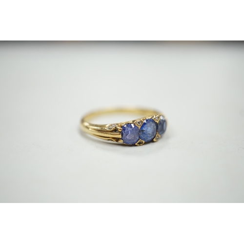 1924 - An early 20th century 18ct and three stone sapphire set half hoop ring, with diamond chip spacers, s... 