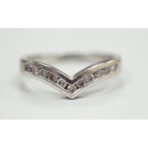 1929 - A modern 18ct white gold and channel set diamond chip wishbone shaped ring, size M, gross 3.4 grams.... 