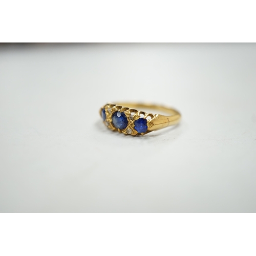 1931 - An Edwardian 18ct gold and graduated three stone sapphire set half hoop ring, with four stone rose c... 