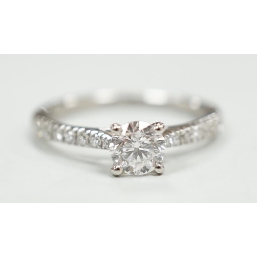 1936 - A modern platinum and single stone diamond ring, with diamond set shoulders and accompanying Gabriel... 