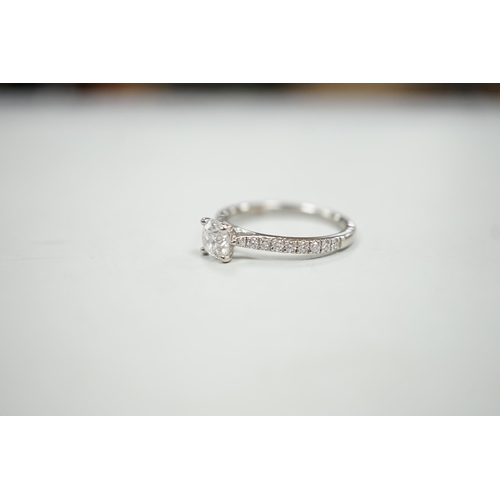 1936 - A modern platinum and single stone diamond ring, with diamond set shoulders and accompanying Gabriel... 