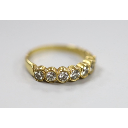 1943 - A modern 750 yellow metal and seven stone diamond set half hoop ring, size O, gross weight 3.2 grams... 