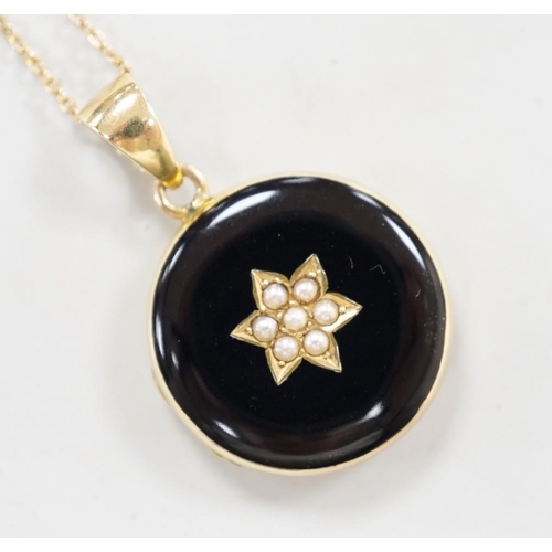 1949 - A late Victorian 15ct, black enamel and seed pearl set circular mourning locket, diameter 23mm, on a... 