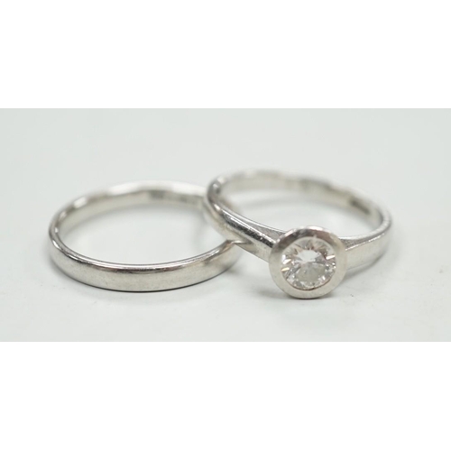 1953 - A modern platinum and collet set solitaire diamond ring, size M, gross weight 4.9 grams, together wi... 