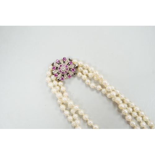 1962 - A 1960's triple strand graduated cultured pearl necklace, with 9ct white gold, ruby and diamond chip... 