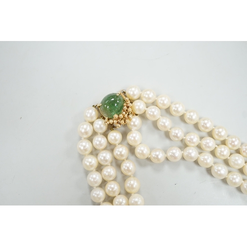 1964 - A mid to late 29th century triple strand cultured pearl choker necklace, with 14k and cabochon emera... 