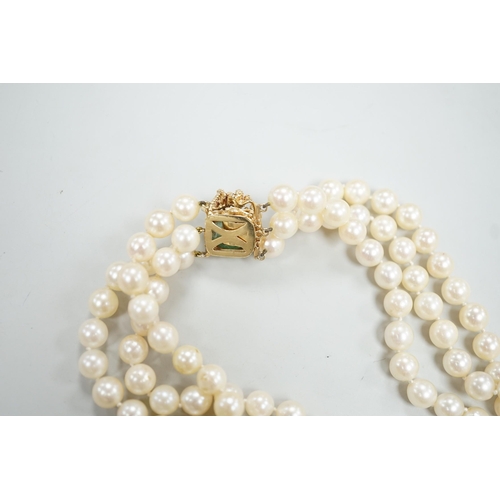 1964 - A mid to late 29th century triple strand cultured pearl choker necklace, with 14k and cabochon emera... 