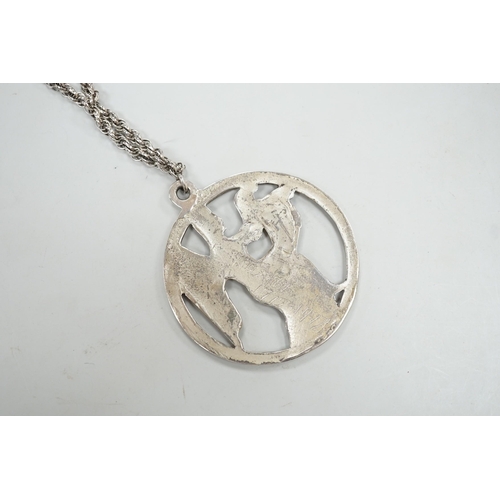 1968 - A late 1970's John Skelton silver pendant, depicting an angel with harp, diameter 63mm, on a sterlin... 