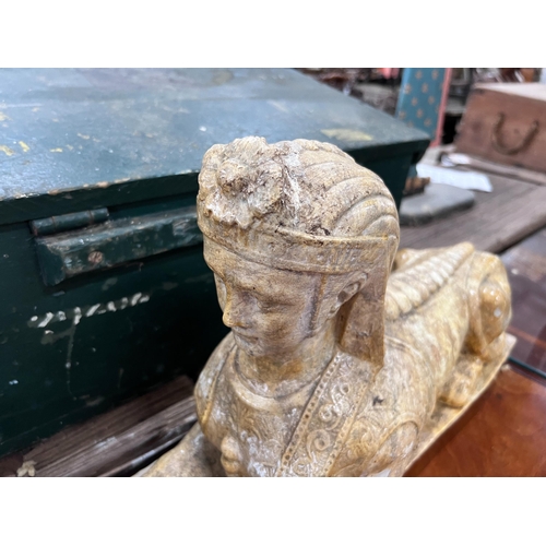 119 - A pair of composition faux marble sphinx, length 48cm, height 30cm *Please note the sale commences a... 