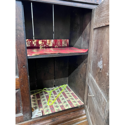 131 - A George III oak press cupboard with two panelled doors over five drawers, width 111cm, depth 53cm, ... 