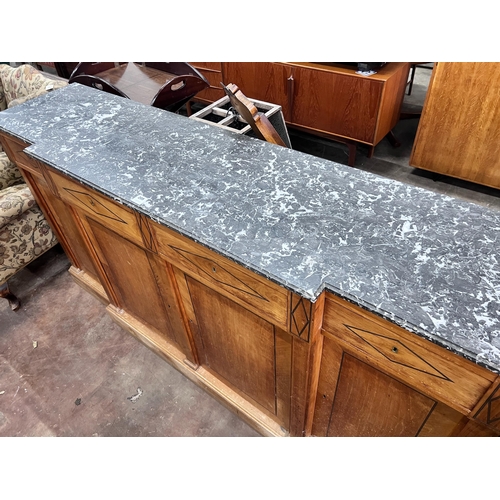 205 - A continental marble topped fruitwood breakfront bookcase, with variegated grey marble top, four dra... 