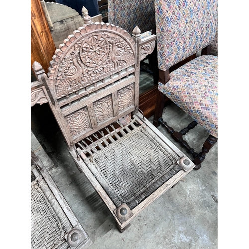 281 - A pair of Indian carved teak low chairs with ropework seats, width 69cm *Please note the sale commen... 