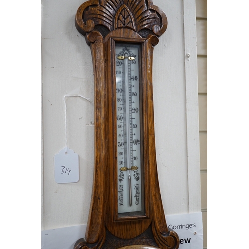 314 - An Edwardian carved oak aneroid wheel barometer, 85cm *Please note the sale commences at 9am.