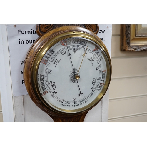 314 - An Edwardian carved oak aneroid wheel barometer, 85cm *Please note the sale commences at 9am.