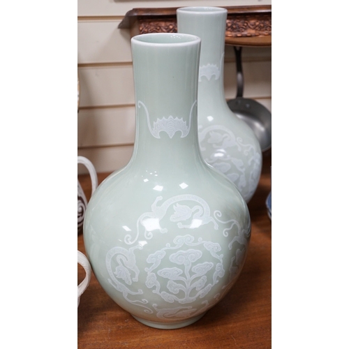 618A - A pair of Chinese white slip decorated celadon glazed bottle vases, mid 20th century, 39cm