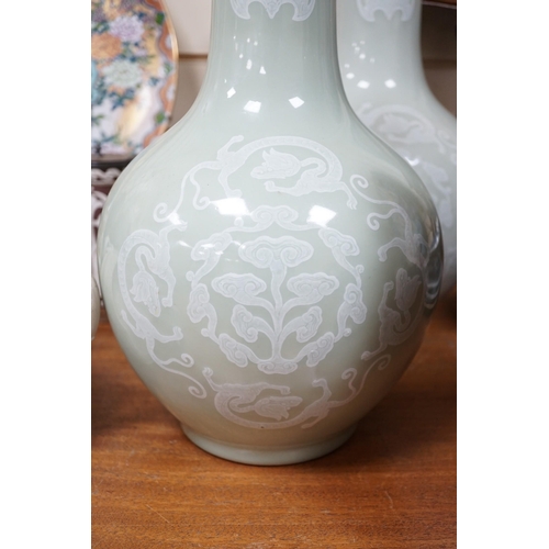 618A - A pair of Chinese white slip decorated celadon glazed bottle vases, mid 20th century, 39cm