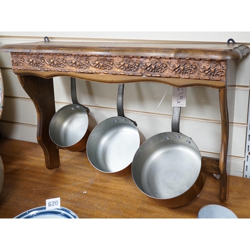 619A - A set of three French copper saucepans, pendant from rack, 57cm wide