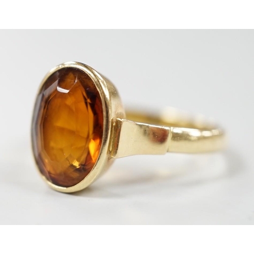 989 - A George V 750 yellow metal and oval cut citrine set ring, size Q, gross weight 5.6 grams.