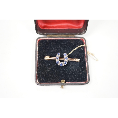 997 - A late Victorian yellow metal. sapphire and diamond cluster set horseshoe bar brooch, 42mm, gross we... 