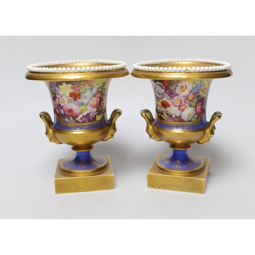 348 - A pair of Minton twin handled urn form vases, hand painted with floral motifs, in the style of Thoma... 