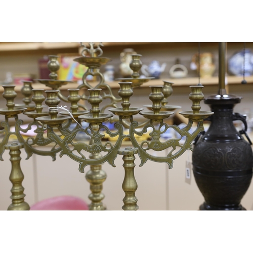411 - Judaica - a pair of Polish brass candelabra and a similar larger candelabrum, tallest 63cm (3)... 